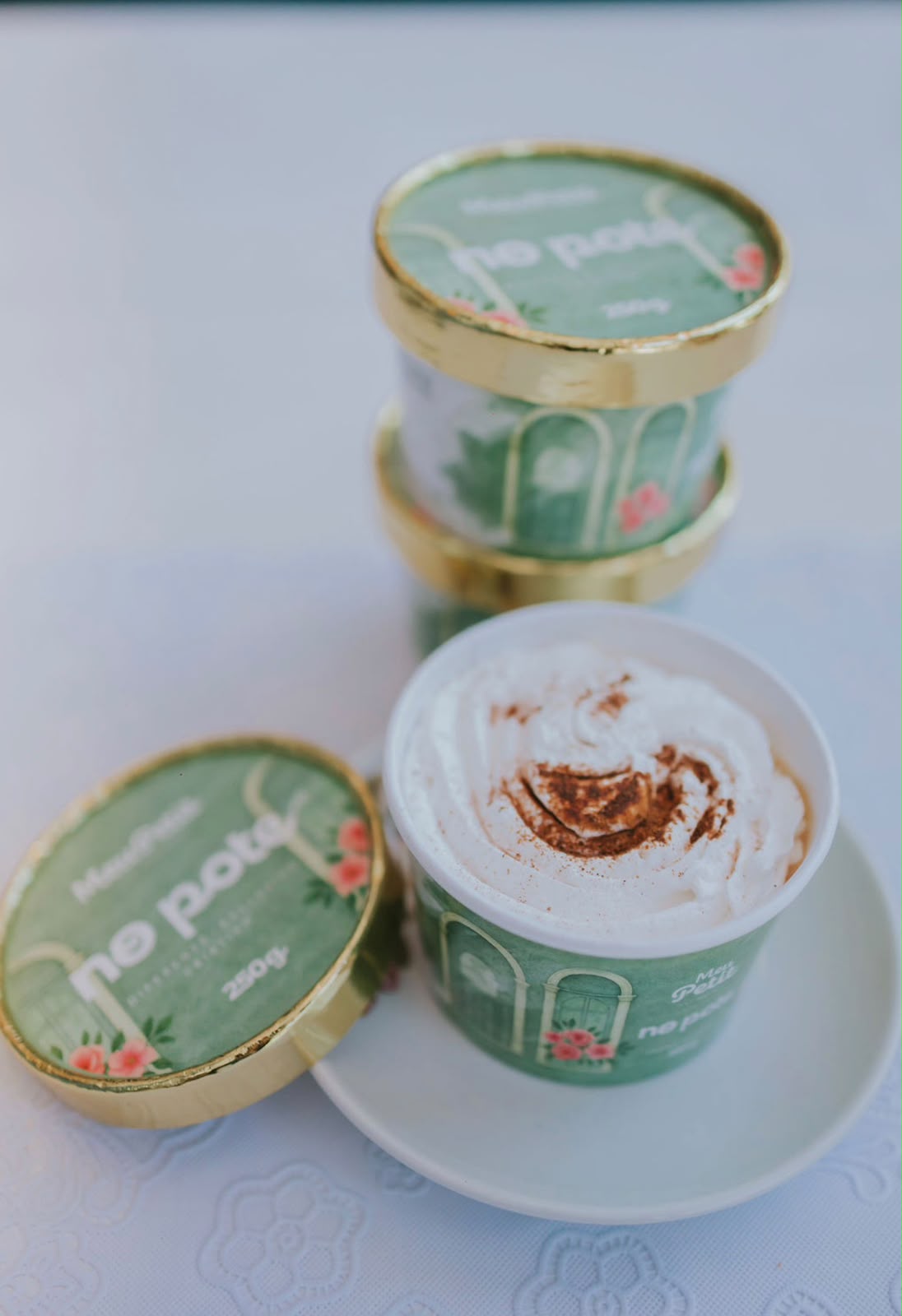 Potes da linha no pote com tampa dourada e rótulo verde da marca